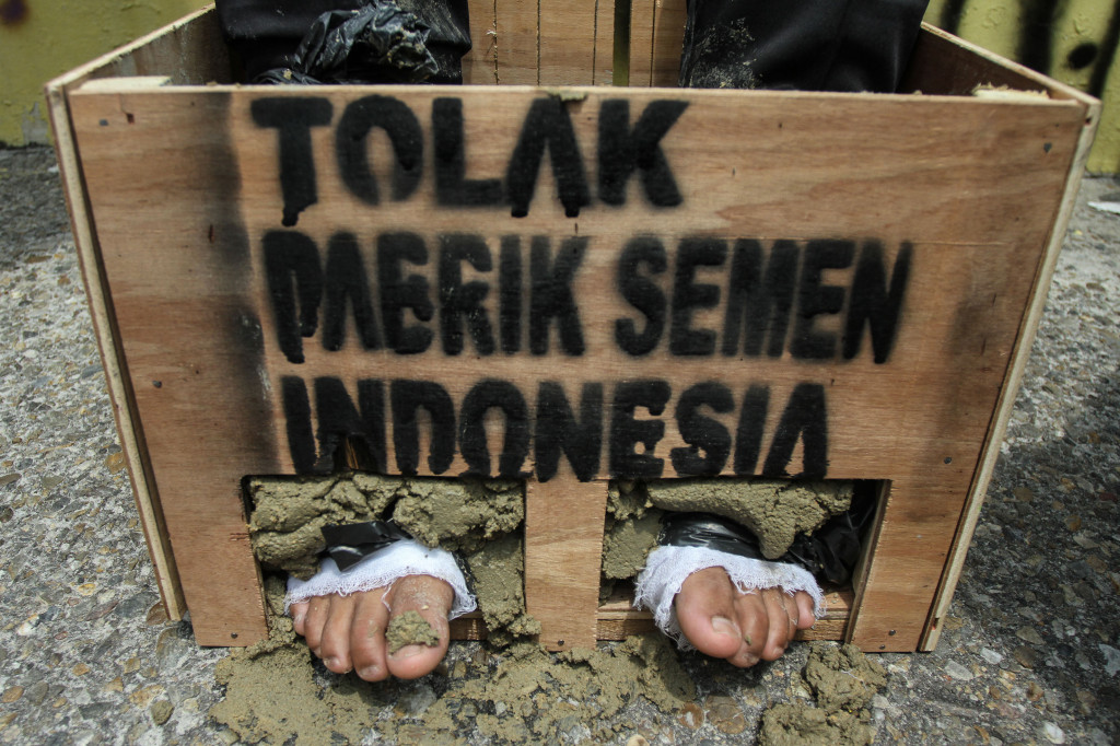 Aktivis lingkungan WALHI Riau melakukan aksi solidaritas peduli Kendeng dengan cara memasung kaki menggunakan semen di Pekanbaru, Riau. (ANTARA/Rony Muharrman)