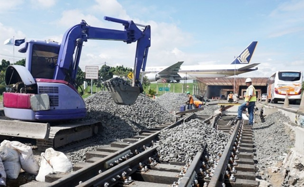 Pekerja PT Kereta Api Indonesia (KAI) menyelesaikan pembangunan rel kereta api bandara Soekarno-Hatta. Foto: Antara/Lucky