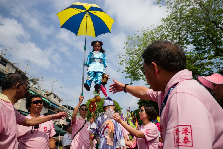 A young girl dressed as a deity on a pedestal takes part in a parade during the Cheung Chau bun festival in Hong Kong on May 3, 2017. (Photo:AFP/Anthony Wallace)