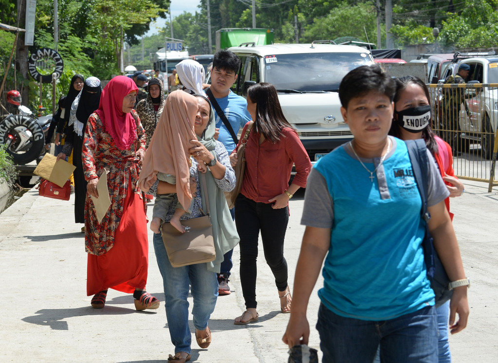 Residents fleeing from Marawi walk through a checkpoint at the entrance of Iligan on southern Philippine island of Mindanao on May 24, 2017. (Photo:AFP/Ted Aljibe)