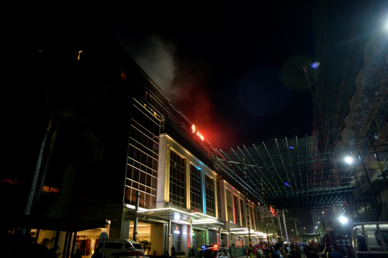 Smoke streamed from Resorts World Manila after a gunman apparently set fire to a gambling table. Police say 36 bodies have now been found in the complex. (Photo:AFP/Noel Celis)