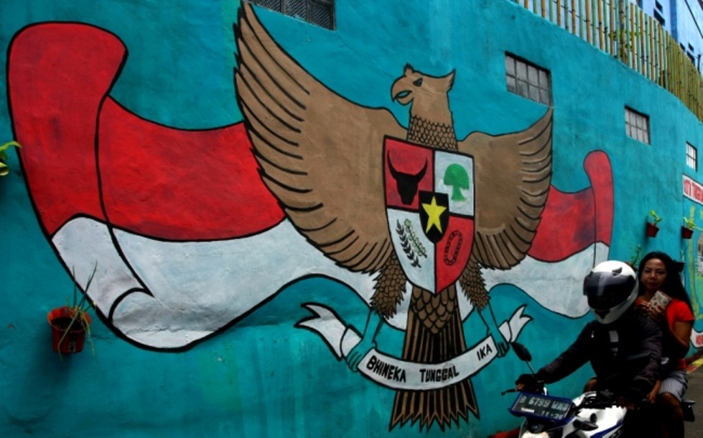 Pengendara melintas di depan mural Garuda Pancasila yang ada di perkampungan warga di Ciputat, Tangerang Selatan, Banten, Senin (28/11)/ANTARA FOTO/Muhammad Iqbal