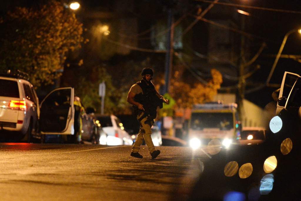 Seorang perwira polisi bersenjata berjalan di tempat kejadian di pinggiran selatan Melbourne Brighton, Senin 5 Juni 2017.  AFP PHOTO / Mal Fairclough.