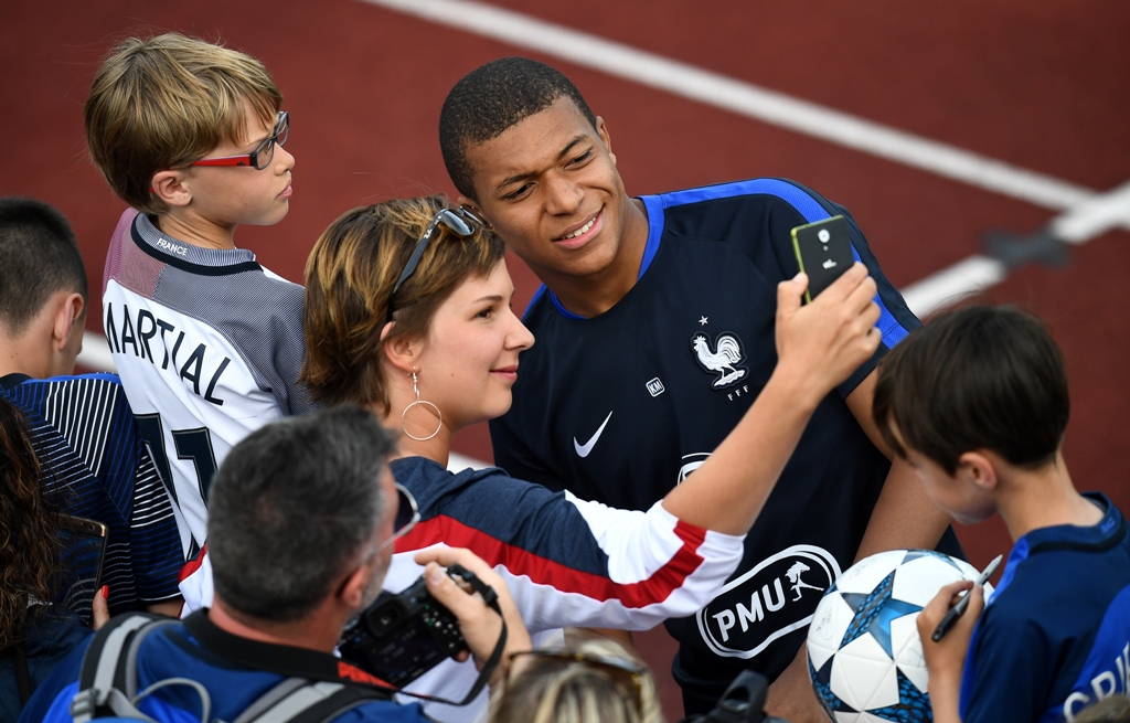 Kylian Mbappe saat berpose dengan penggemar (Foto: AFP)