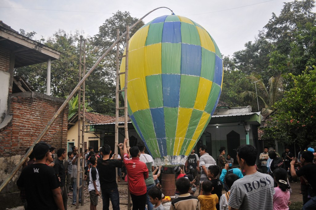 Tradisi menerbangkan balon udara raksasa bersamaan di tiap musola ini untuk merayakan Lebaran Ketupat atau biasa disebut Kupatan -- Foto: Antara/Syaiful Arif