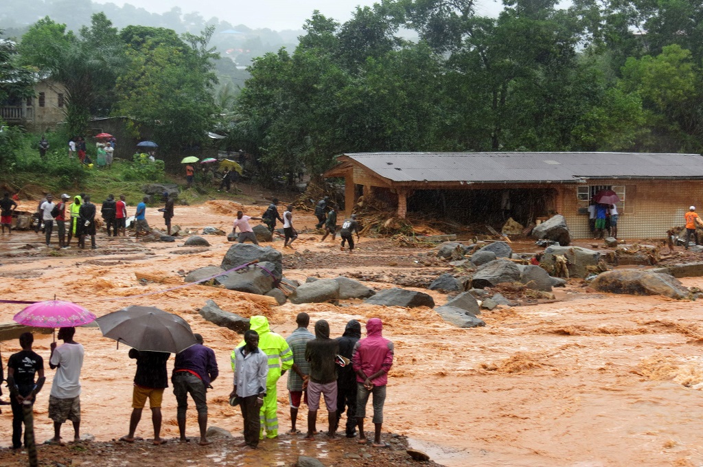 Warga menyaksikan banjir bercampur lumpur di Freetown, Sierra Leone, 14 Agustus 2017. (Foto: AFP/SAIDU BAH)