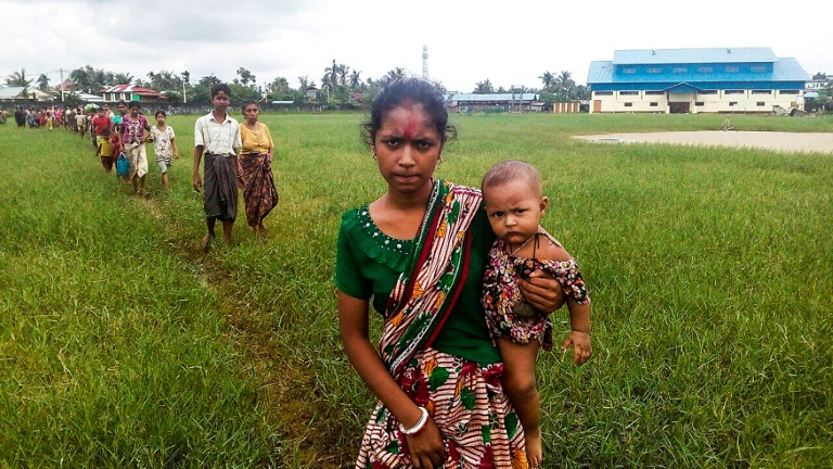 A woman holds a child in her arms as she arrives at Yathae Taung township in Rakhine state after fleeing violence in their home village. (Photo:AFP/Wai Moe)
