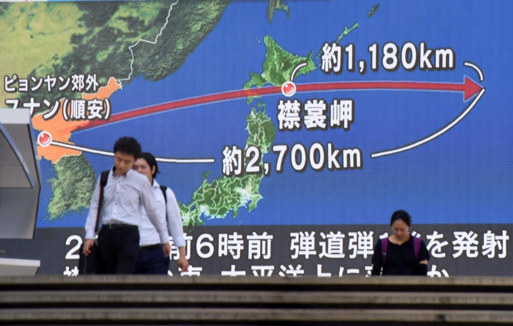 Pedestrians walk in front of a huge screen displaying a map of Japan and the Korean Peninsula, in Tokyo on August 29, 2017, following a North Korean missile test that passed over Japan. (Photo:AFP/Kazuhiro Nogi)