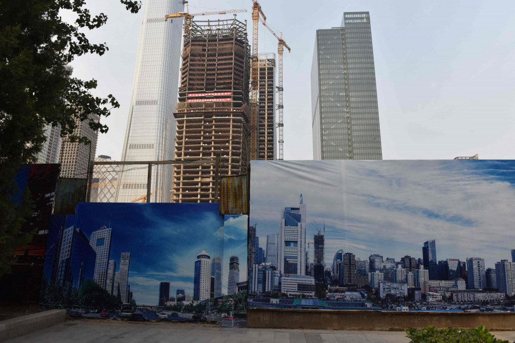 Billboard illustrations of Beijing's central business district are seen in front of a construction site in Beijing on October 16, 2017. (Photo:AFP/Greg Baker)