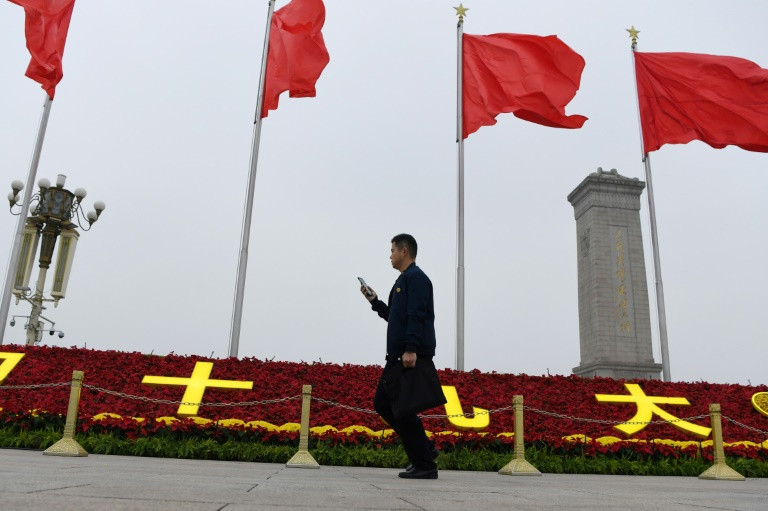 A man walks past decorations for the Communist Party's 19th Congress in Tiananmen Square, on the eve of its opening. (Photo:AFP/Greg Baker)