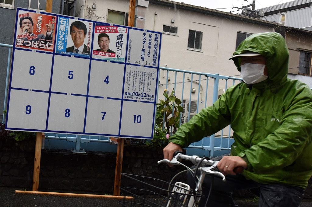 Seorang pria melewati poster-poster kampanye di Tokyo, 19 Oktober 2017, menjelang pemilu nasional Jepang pada 22 Oktober. (Foto: AFP/KAZUHIRO NOGI)