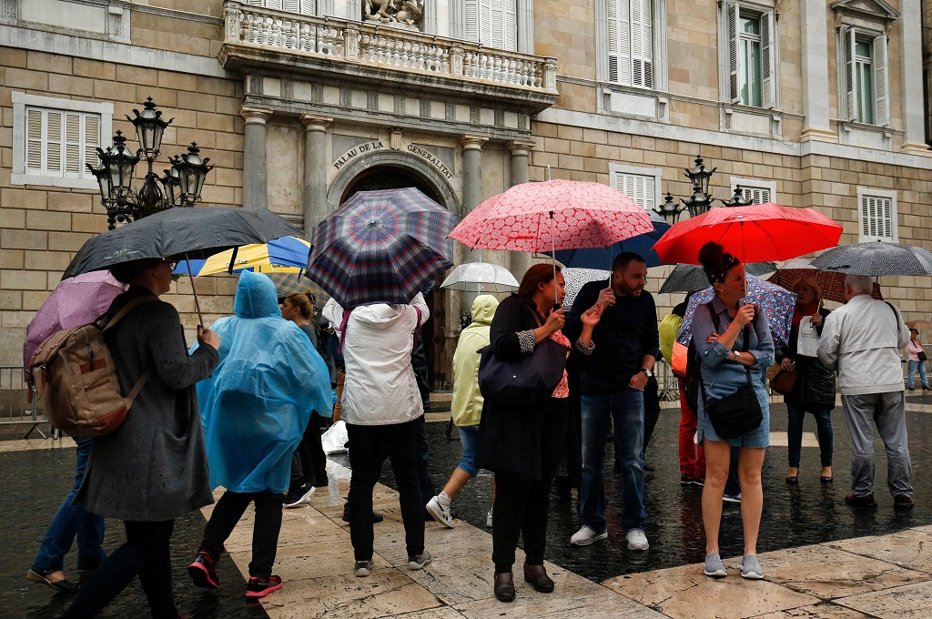 Para turis di depan Istana Generalitat, Barcelona, Spanyol, 19 Oktober 2017. (Foto: AFP/PAU BARRENA)
