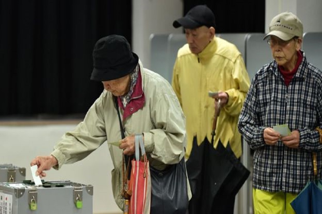 Warga Jepang membawa payung untuk mengikuti pemilu di tengah guyuran hujan deras imbas Badai Lan, Minggu 22 Oktober 2017. (Foto: AFP)