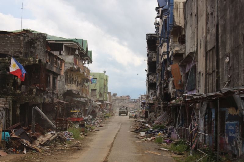 A military vehicle drives past destroyed buildings Marawi (Photo:AFP/Merlyn Manos)
