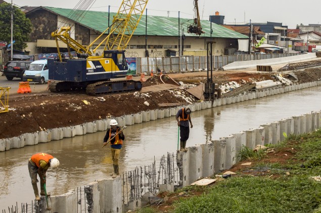 Ilustrasi: Sejumlah pekerja menyelesaikan pemasangan turap di Sungai Kalimalang, Jakarta. Foto: Antara/Galih Pradipta.