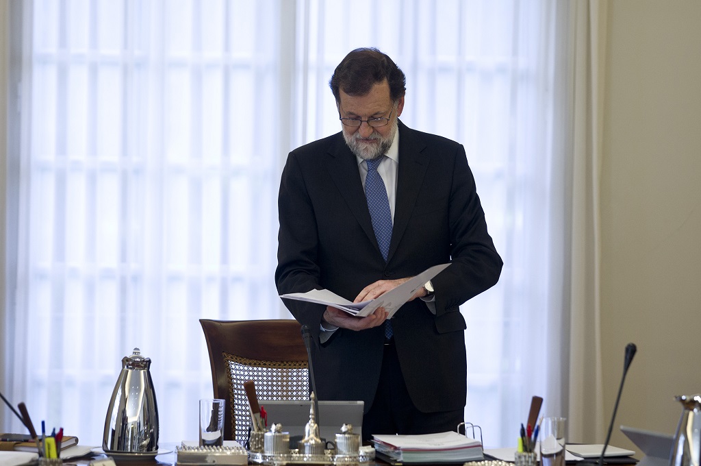 PM Spanyol Mariano Rajoy membaca dokumen sebelum pertemuan di Istana Moncloa, Madrid, 27 Oktober 2017 . (Foto: AFP/DIEGO CRESPO)