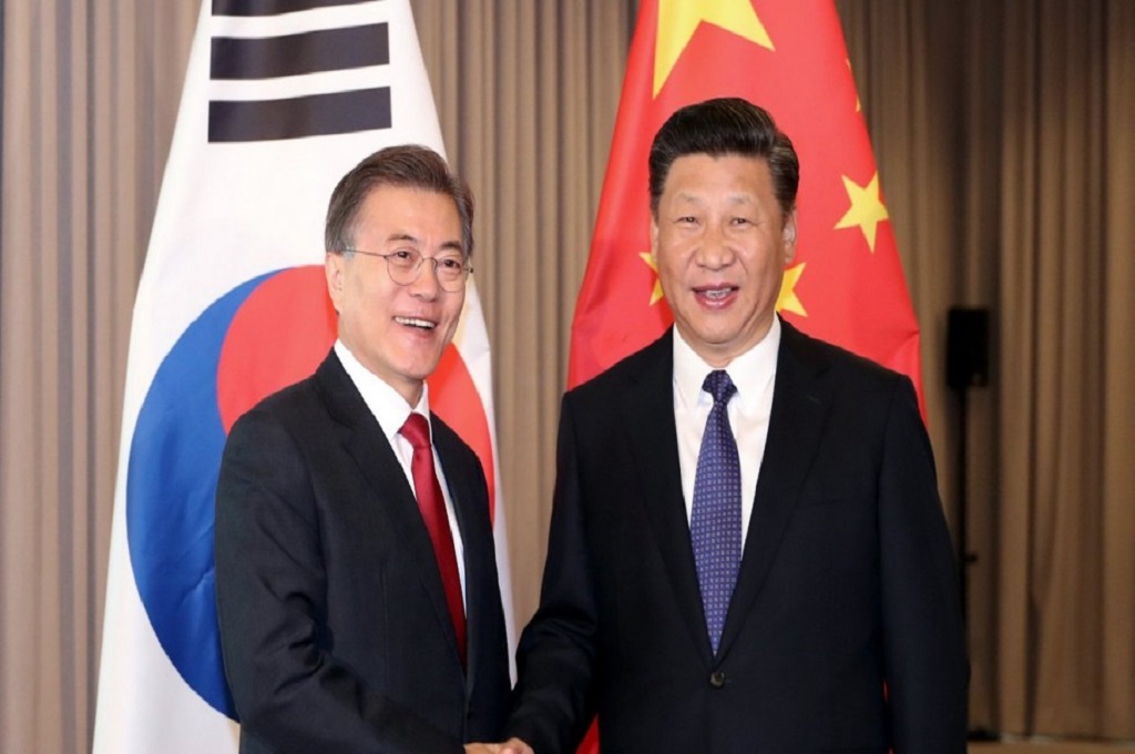 Presiden Korsel Moon Jae-in (kiri) berjabat tangan dengan Presiden Xi Jinping di Berlin, Jerman, Juli 2017. (Foto: EPA)