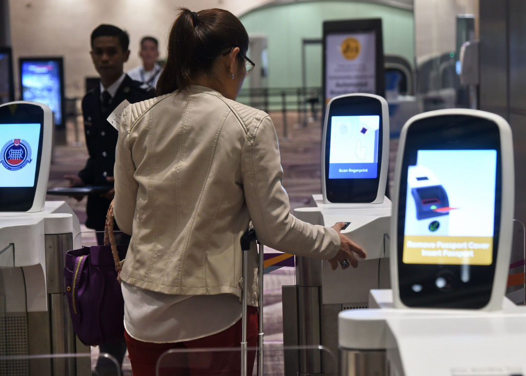 A passenger scans her thumb on an automated immigration gate at the newly-opened Changi International Airport's Terminal 4 in Singapore on October 31, 2017. (Photo:AFP Roslan Rahman)
