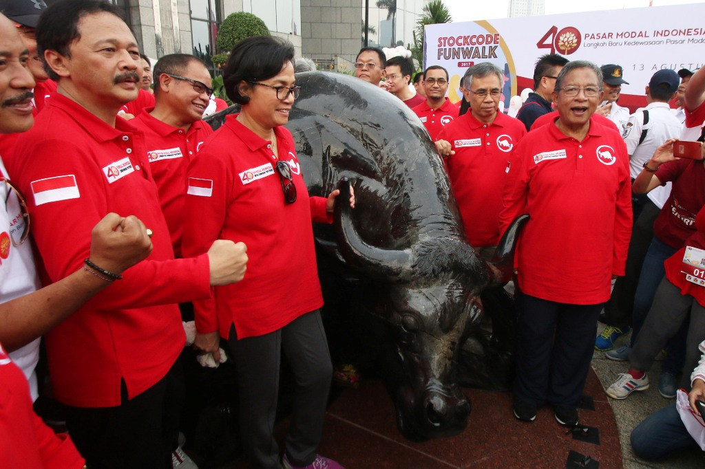 Menkeu Sri Mulyani Indrawati (kedua kiri) bersama Menko Darmin Nasution (kanan), Direktur Utama BEI Tito Sulistio (kiri), dan Ketua DK-OJK Wimboh Santoso (kedua kanan) berfoto di depan patung Banteng Wulung  (ANTARA FOTO/Rivan Awal Lingga)