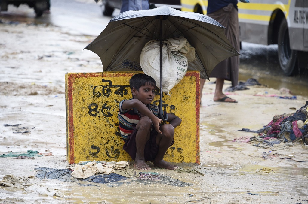 Seorang bocah pengungsi menggunakan payung di kamp Kutupalong, Bangladesh, 19 September 2017. (Foto: AFP/DOMINIQUE FAGET)