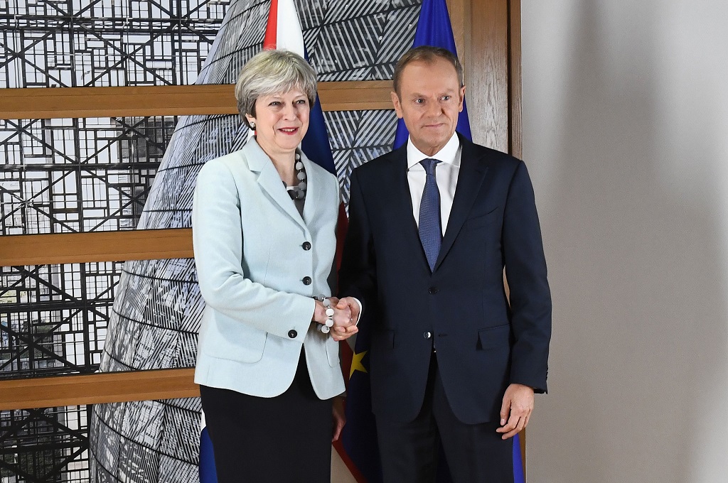 PM Inggris Theresa May (kiri) berjabat tangan dengan Presiden Uni Eropa Donald Tusk di Brussels, Belgia, 8 Desember 2017. (Foto: AFP/EMMANUEL DUNAND)
