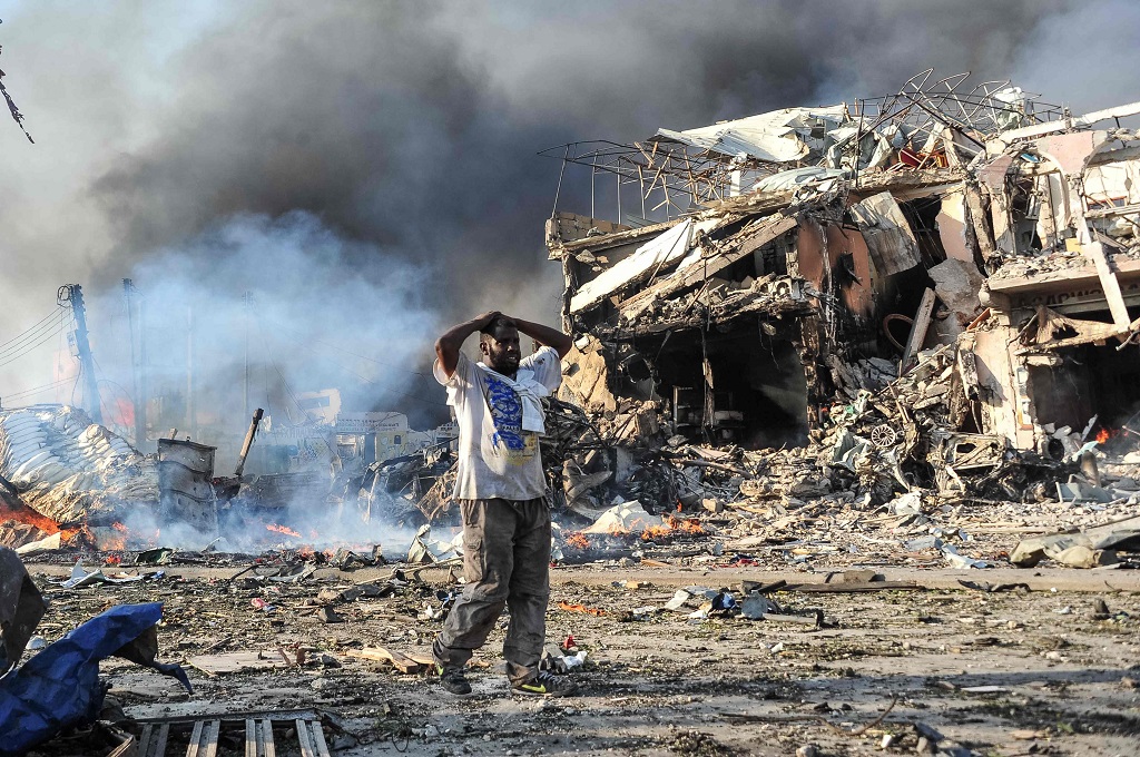 Seorang pria berada di lokasi bom bunuh diri di Mogadishu, Somalia, 14 Oktober 2017. (Foto: AFP/MOHAMED ABDIWAHAB)