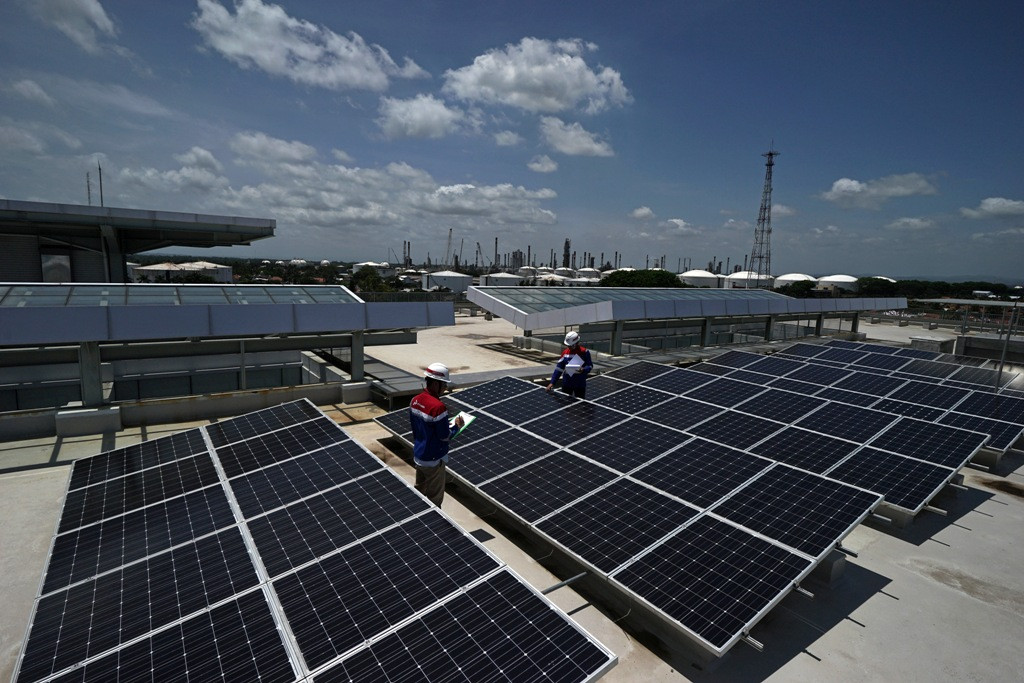 Dua petugas melakukan pengecekan panel surya yang dipasang di Gedung Head Office Pertamina RU IV, di Cilacap, Jawa Tengah (ANTARA FOTO/Idhad Zakaria)