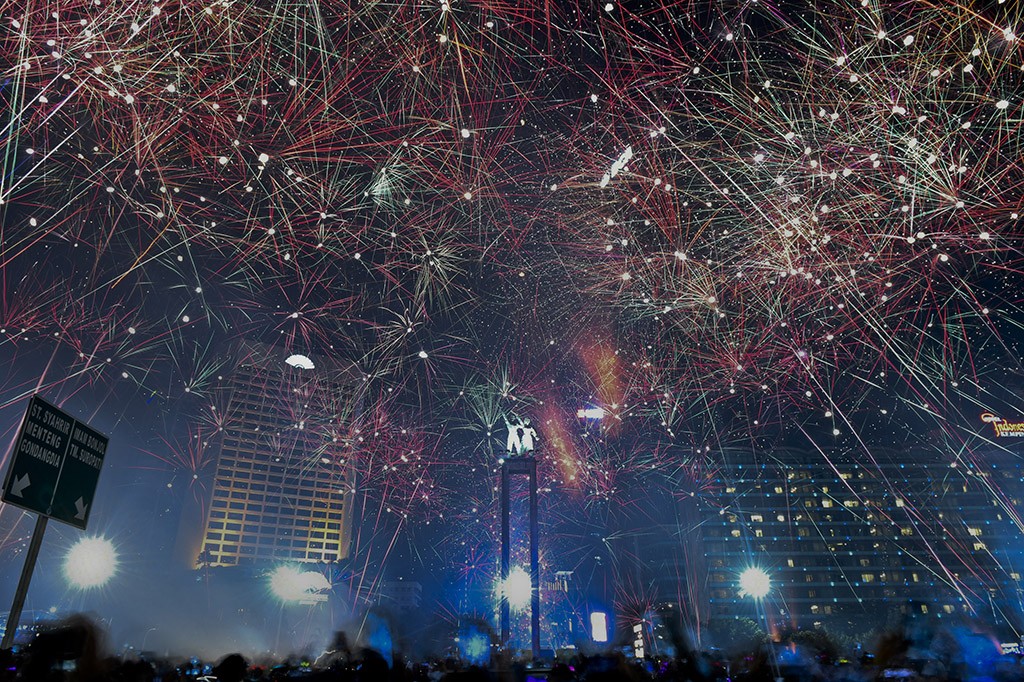 Suasana pesta kembang api saat malam tahun baru 2018 di kawasan Bundaran HI, Jakarta. Sejumlah warga ibukota dan sekitarnya memadati kawasan itu untuk merayakan malam pergantian tahun 2017 ke 2018. ANTARA FOTO/Hafidz Mubarak A