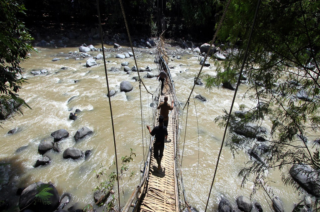 Polisi melintasi jembatan gantung yang ambruk menuju objek wisata penangkaran rusa di Bogor, Selasa 2 Januari 2018, Ant - Yulius Satria Wijaya