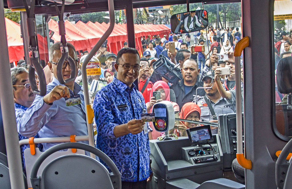 Gubernur DKI Jakarta Anies Baswedan menunjukkan kartu One Karcis One Trip (OK Otrip) saat meninjau Jalan Jatibaru Raya, Tanah Abang, Jakarta. Foto: Antara/Galih Pradipta.