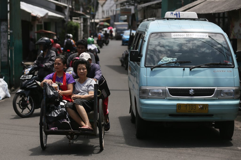 Warga menaiki transportasi becak di kawasan Petak Sembilan, Jakarta Barat. (Foto: MI/Ramdani)