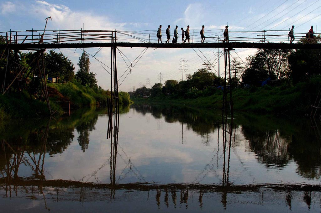 Sejumlah siswa berjalan melewati jembatan bambu yang berada di atas Sungai Banjir Kanal Barat, di kawasan Lemah Gempal Semarang, Jateng -- ANT/Andreas Fitri Atmoko