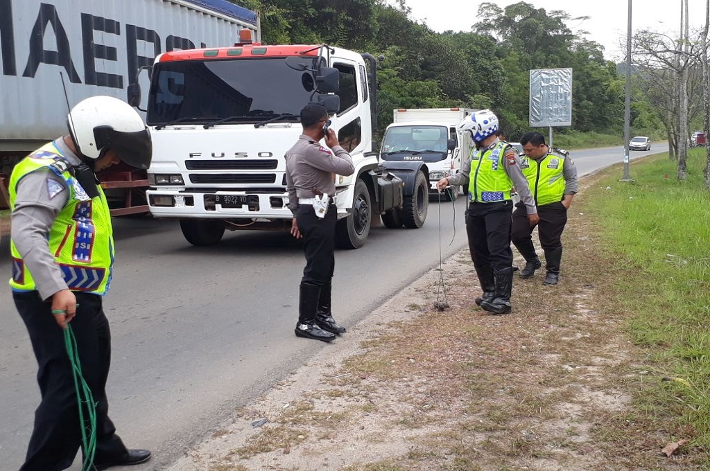 Polisi menyisiri salah satu jalan di Batam untuk menemukan paku dan potongan baja yang dapat mengganggu keselamatan pengendara, Senin, 5 Maret 2018, Medcom.id - Anwar Sadat Guna