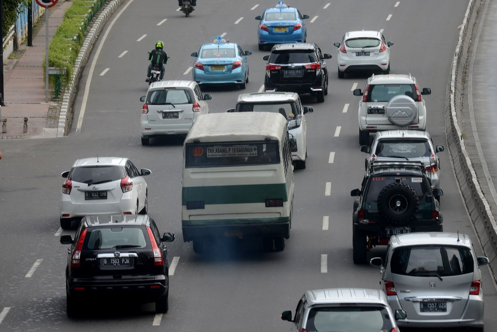 Bus Kopaja dengan asap knalpot yang pekat melintas di kawasan Sudirman, Jakarta. (Foto: MI/Susanto)