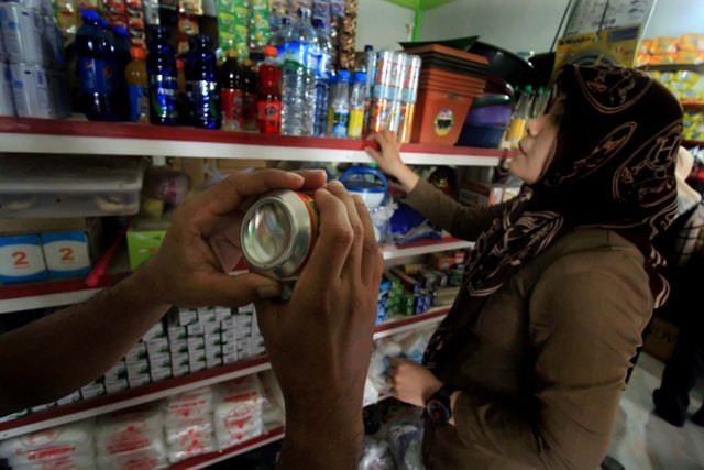 Petugas memeriksa produk kedaluwarsa. Foto: Antara/Rahmad