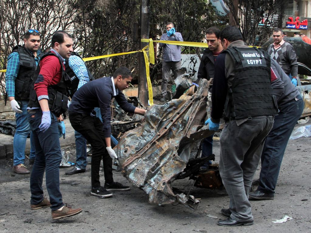Tim Forensik Mesir dan pasukan keamanan memeriksa lokasi serangan bom di Kota Alexandria. (Foto: AFP/STR).