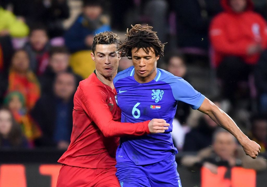 Penyerang timnas Portugal, Cristiano Ronaldo, susah payah merebut bola dari bek timnas Belanda, Nathan Ake. (AFP PHOTO / Fabrice COFFRINI)