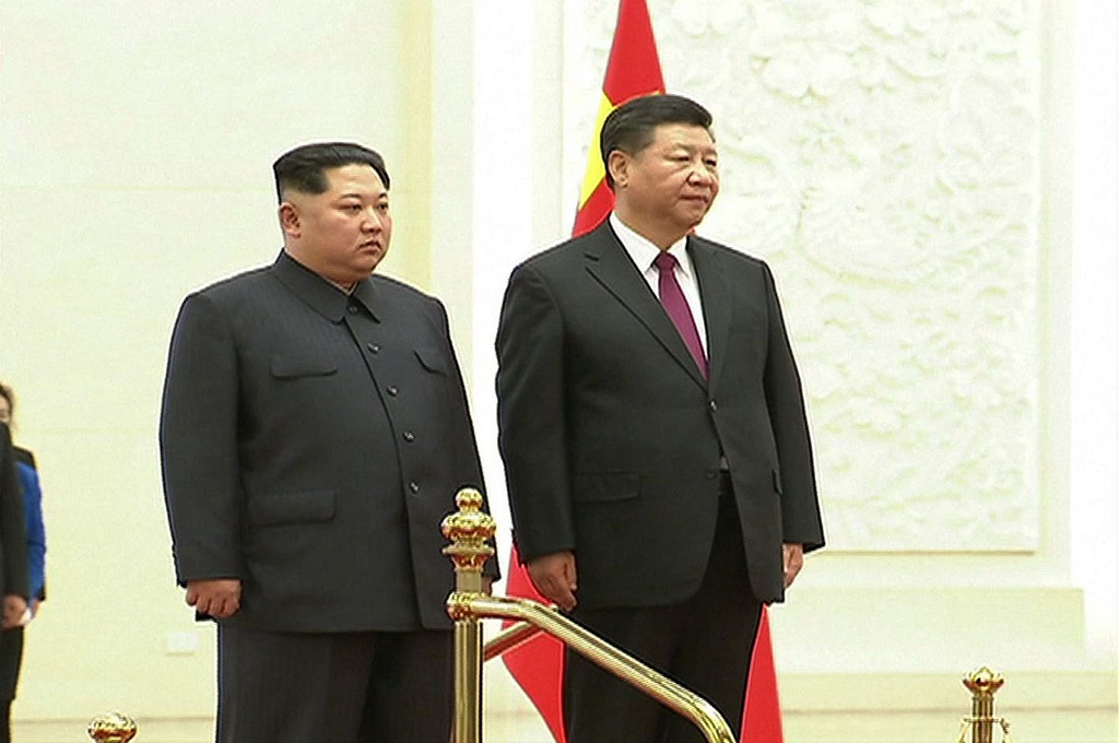 Kim Jong-un (kiri) bersama Presiden Tiongkok Xi Jinping di Beijing, 27 Maret 2018. (Foto: AFP/CCTV)