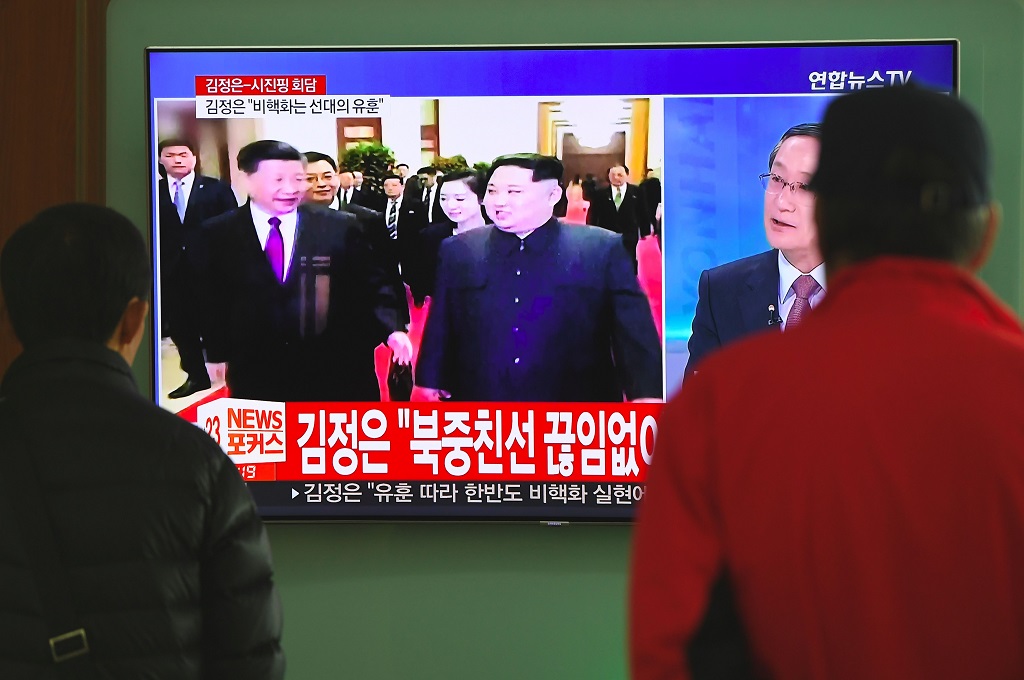Warga Korsel di Seoul, 28 Maret 2018, menonton berita pertemuan Kim Jong-un dengan Xi Jinping di Beijing, Tiongkok. (Foto: AFP/JUNG YEON-JE)