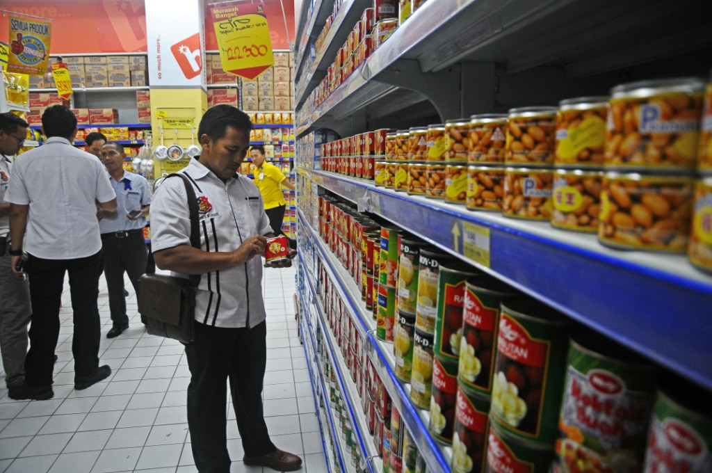 Anggota Satreskrim memeriksa sejumlah makanan saat razia makanan kedalurwarsa di salah satu pusat perbelanjaan di Kudus, Jawa Tengah. Foto: Antara/Yusuf Nugroho.