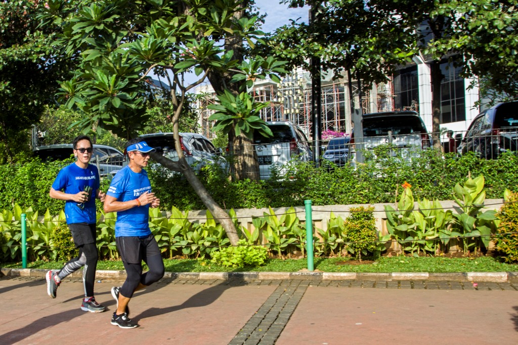 Wakil Gubernur DKI Jakarta Sandiaga Uno (kanan) berlari menuju Balai Kota, di Jakarta. Foto: Antara/Galih Pradipta.