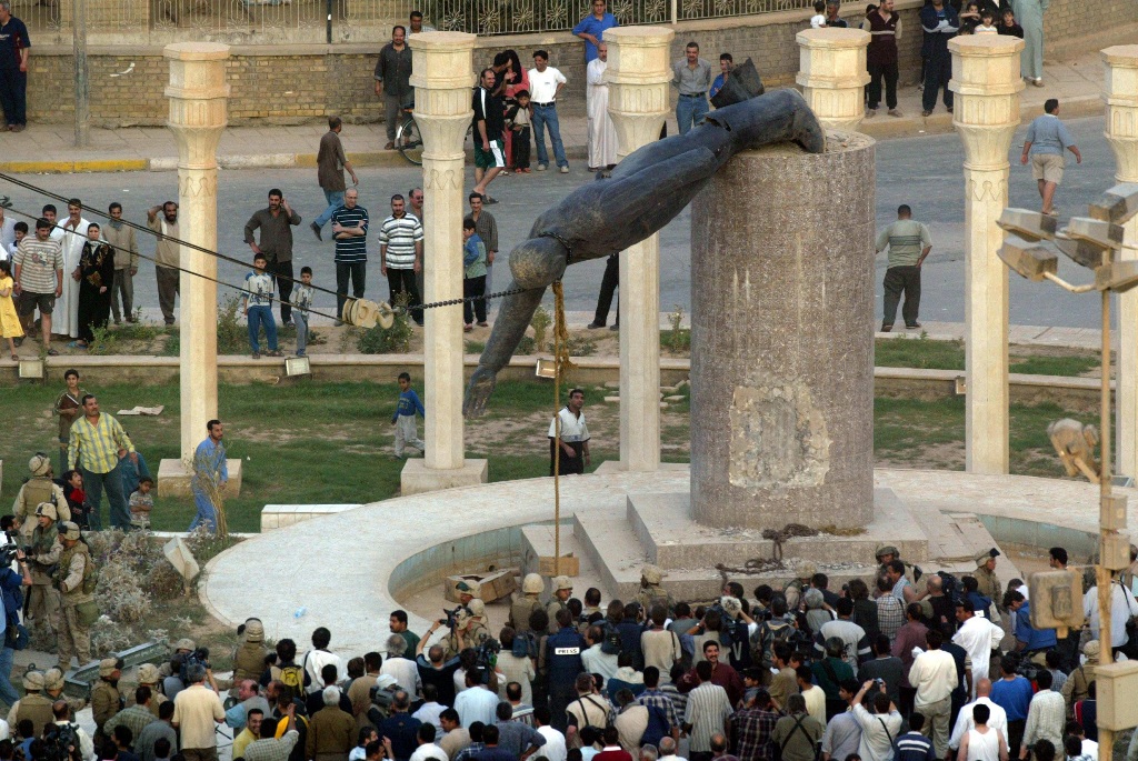On April 9, 2003 Iraqis watch a statue of Iraqi President Saddam Hussein falling in Baghdad (Photo: AFP)