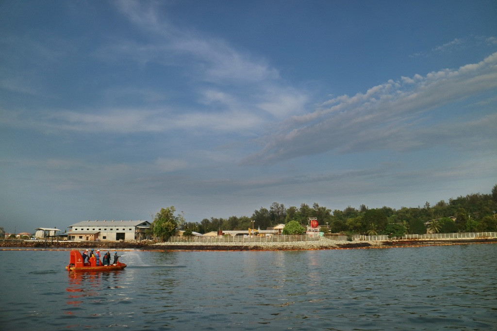 Sejumlah petugas Pertamina menyemprotkan cairan khusus untuk membersihkan minyak di perairan Jetty Dermaga Pelabuhan Pertamina di Balikpapan. (FOTO: ANTARA/Sheravim)