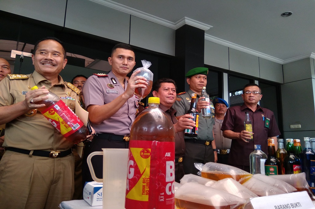 Kapolres Metro Bekasi dan jajaran pimpinan menunjukkan miras oplosan yang disita dalam razia, Senin, 16 April 2018, Medcom.id - Antonio