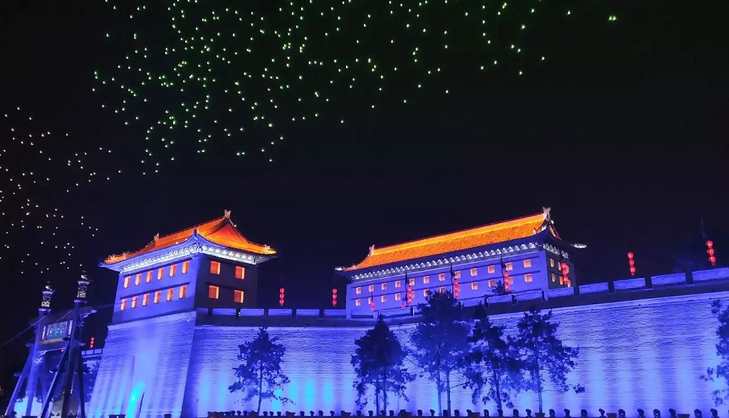 Drone berhiasakan lampu warna warni terbang di atas pagar kota bersejarah Xian provinsi Shaanxi, Tiongkok.