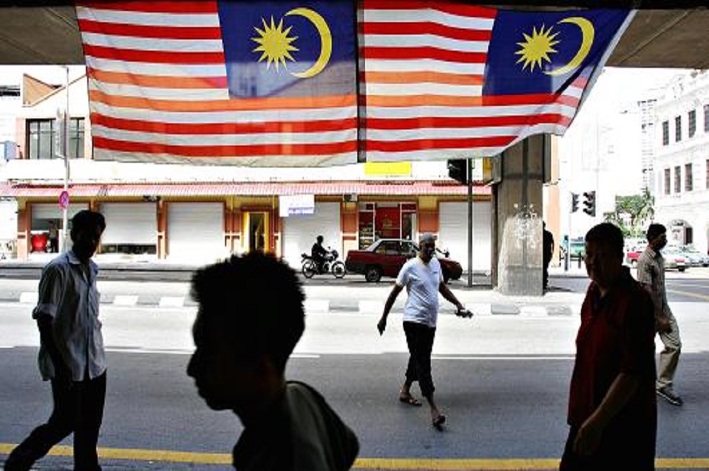 Warga beraktivitas di sekitar dua bendera Malaysia. (Foto: AFP/Getty)