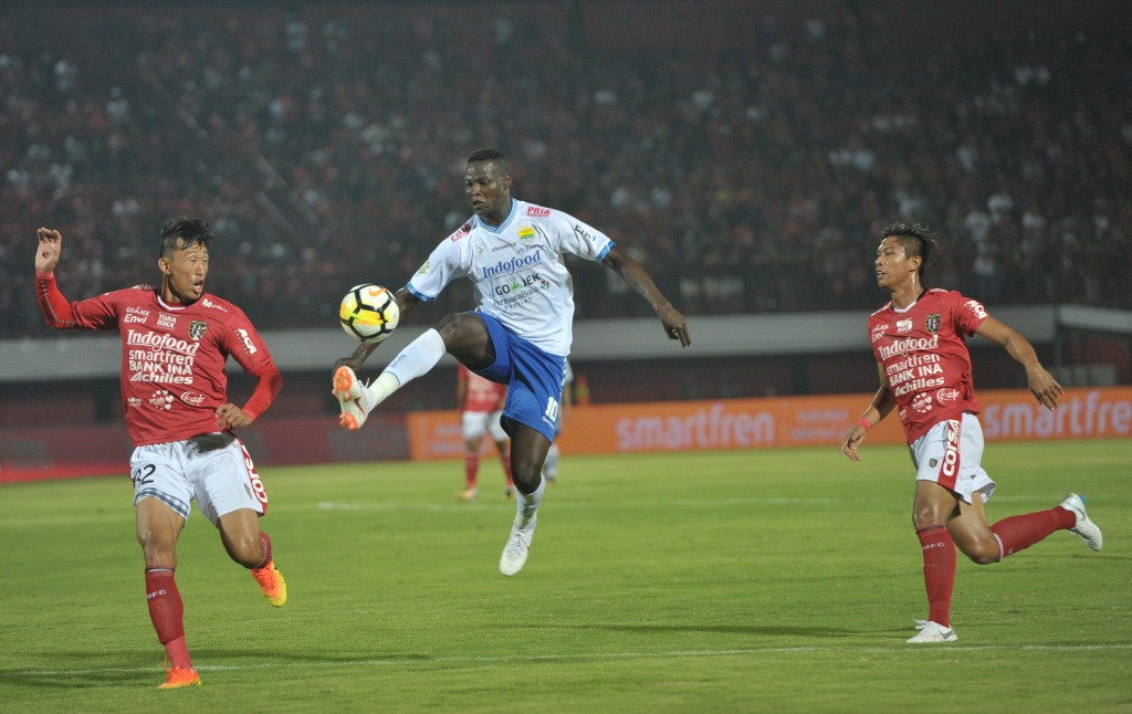 Pesepak bola Persib Bandung Ezechiel Nduasel (tengah) berebut bola dengan pesepak bola Bali United Ahn Byung Keon (kiri) dalam Pertandingan Sepak Bola Liga 1 2018 di Stadion I Wayan Dipta, Gianyar, Bali, Minggu (27/5) (Foto: Antara/Nyoman Budhiana)