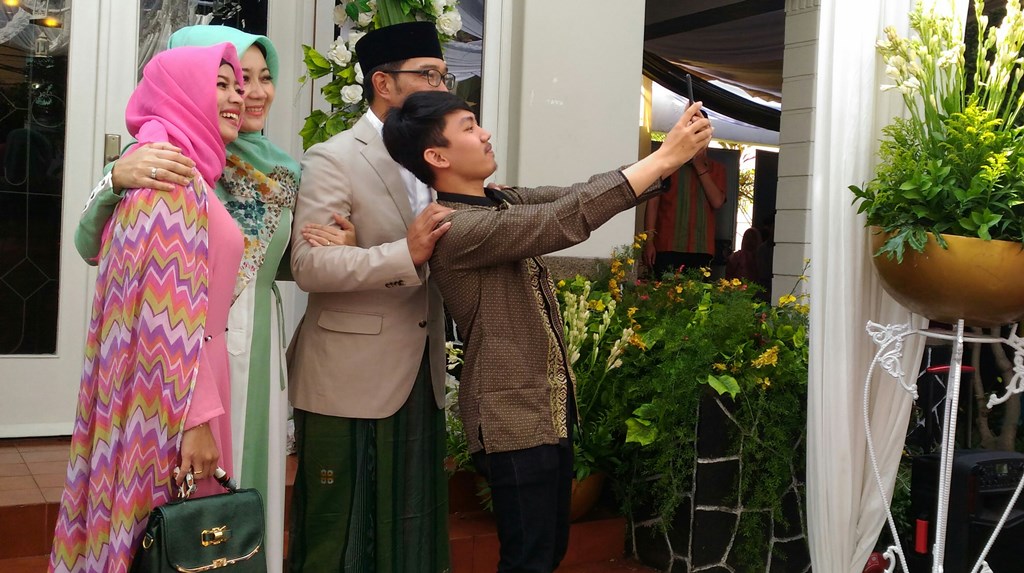 Ridwan Kamil dan sang istri Atalia Praratya saat berswafoto bersama warga di acara open house, Jalan Cipaganti, Kota Bandung, Jawa Barat, Jumat 15 Juni 2018. (Foto: Roni K)