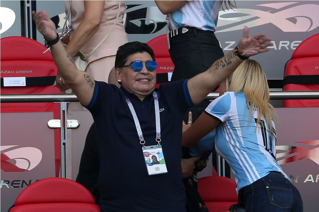 Maradona (kiri) bersama pacarnya, Rocio Oliva menyaksikan laga Argentina di Piala Dunia 2018. (Foto: AFP PHOTO / Roman Kruchinin)
