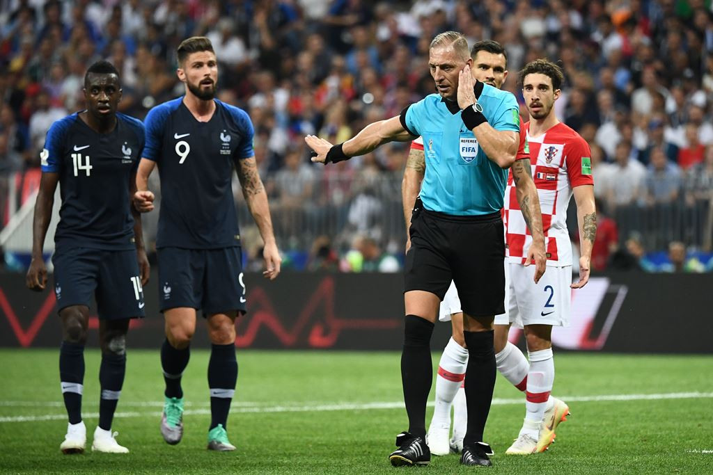 Momen wasit Nestor Pitana mendengarkan laporan VAR. (Foto: AFP/Franck Fife)